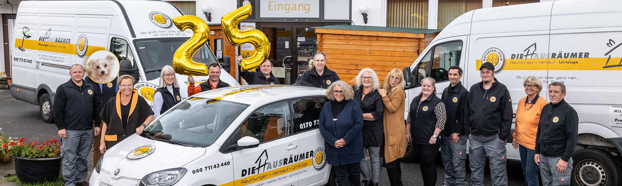 Das Bild zeigt das gesamte Team der Hausräumer vor dem Gebrauchtwarenladen in Reinbek bei Hamburg. Das Team strahlt in die Kamera, da es Haushaltsauflösungen, Räumungen und Umzüge aus Leidenschaft und mit viel Spaß an der Arbeit macht. 